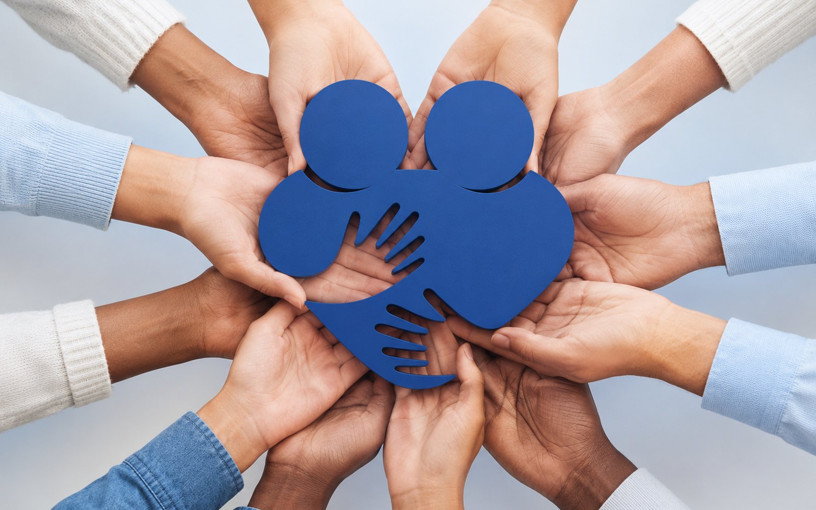 Des mains de plusieurs personnes portant ensemble le symbole de Mon Couple Magazine